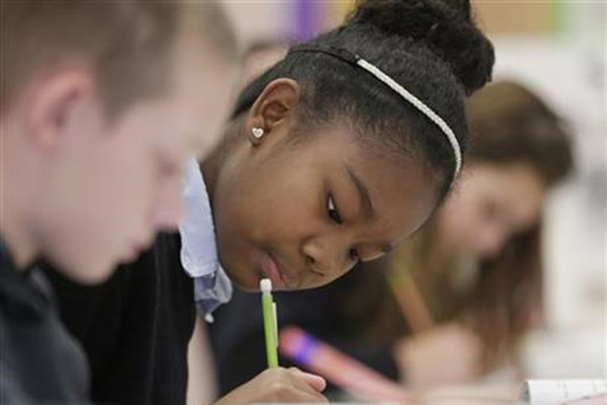 In this Tuesday, Nov. 17, 2015 photo, Renee Pascoe works in her seventh grade accelerated math class at Holy Spirit School in East Greenbush, N.Y.  (AP Photo/Mike Groll)