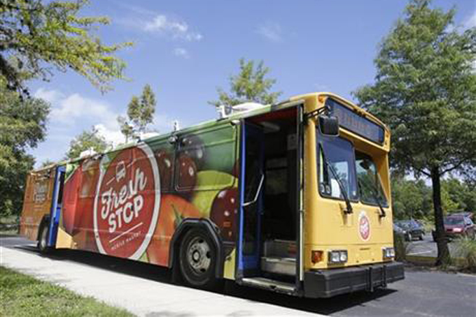 In this Wednesday, July 15, 2015 photo, The Fresh Stop, a mobile market stops at the Taft Community Center in Orlando, Fla.  (AP Photo/John Raoux)