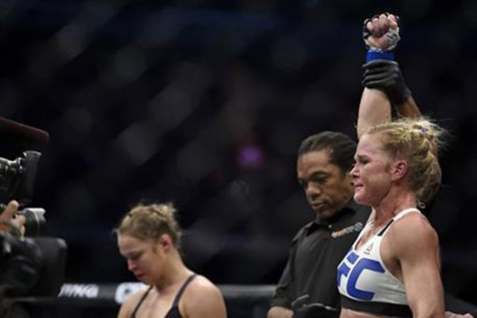 Holly Holm, right, celebrates after defeating Ronda Rousey, left, during their UFC 193 Bantamweight title fight in Melbourne, Australia, Sunday, Nov. 15, 2015. (AP Photo/Andy Brownbill)