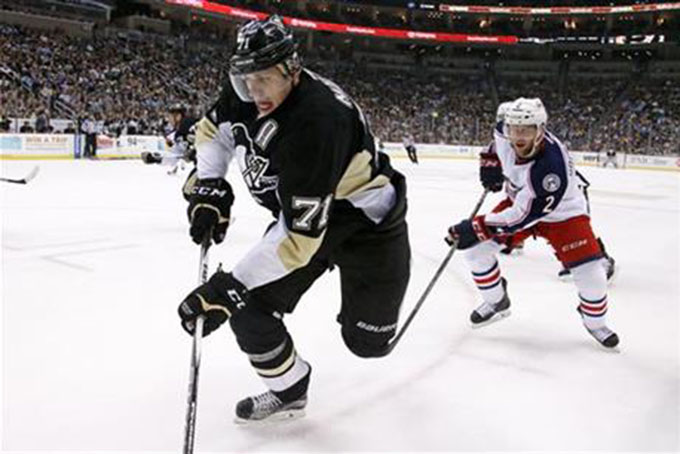 Pittsburgh Penguins' Evgeni Malkin (71) works the puck in the corner against Columbus Blue Jackets' Andrew Bodnarchuk (2) during the second period of an NHL hockey game in Pittsburgh, Monday, Dec. 21, 2015. (AP Photo/Gene J. Puskar)