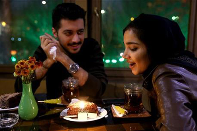 An Iranian woman celebrates her birthday with her friend at a cafe in downtown Tehran, Iran, Tuesday, Dec. 8, 2015. (AP Photo/Ebrahim Noroozi)