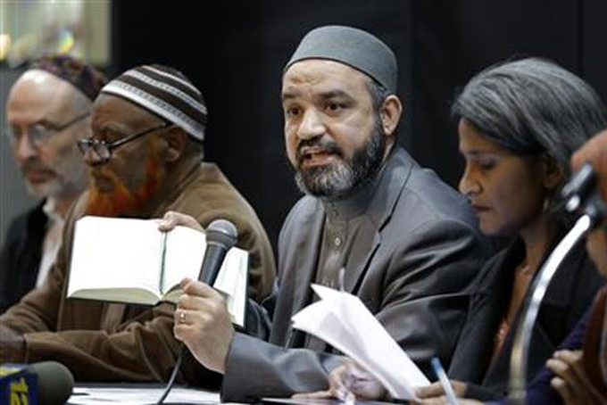 In this Wednesday, Nov. 18, 2015 file photo, Aly Kamel, an imam from the Bronx Muslim Center, holds a Quran before reading from it during a news conference in New York. Kamel joined other religious and community leaders to denounce the terror attacks in Paris. (AP Photo/Seth Wenig)