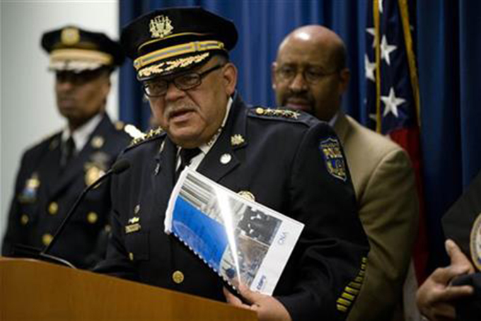 Philadelphia Police Commissioner Charles Ramsey, center, refers to the Justice Department's six-month assessment report in his hand as Mayor Michael Nutter, right, and Deputy Commissioner Richard Ross, left, listen during a news conference Tuesday, Dec. 22, 2015, in Philadelphia. .(AP Photo/Matt Rourke)