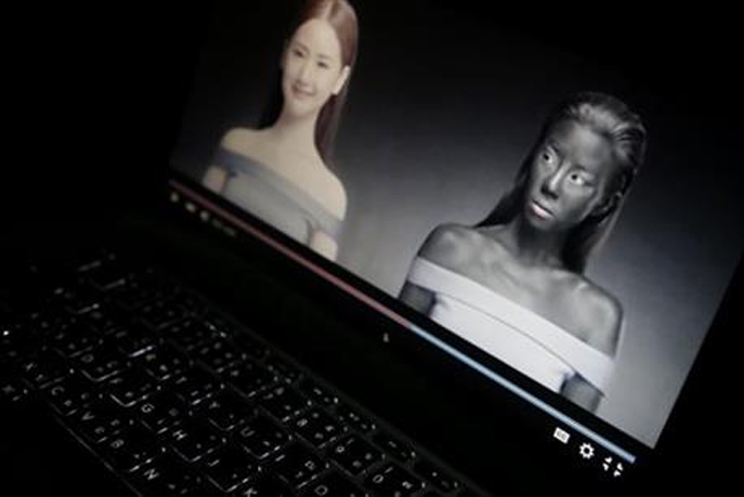 An online advertisement by Thai cosmetics company Seoul Secret showing Thai actress Cris Horwang, right, is displayed on a computer screen in Bangkok, Thailand, Friday, Jan. 8, 2016. (AP Photo/Charles Dharapak)