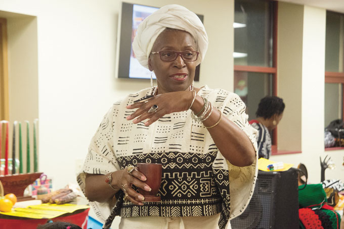 HUBERTA JACKSON-LOWMAN pours libation at the Ujamaa Collective’s Kwanzaa event held at the Grayson Center, in the Hill.