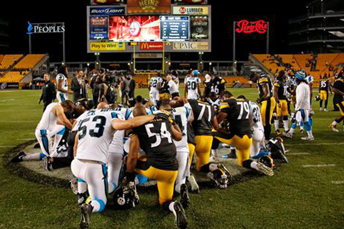 Carolina Panthers and Pittsburgh Steelers players gather at mid-field for a prayer following an NFL pre-season football game in Pittsburgh, Thursday, Aug. 28, 2014. The Panthers won 10-0. (AP Photo/Gene J. Puskar)