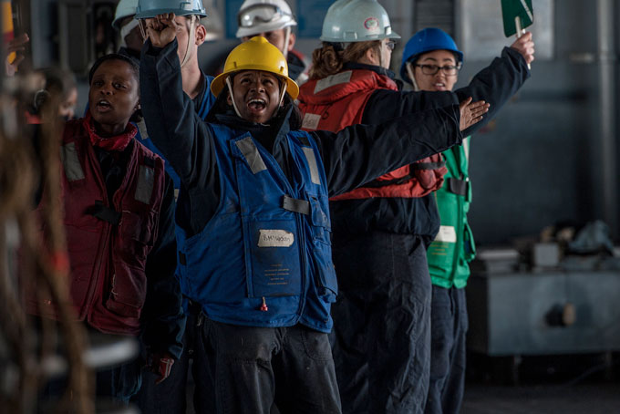 PITTSBURGHER GOES TO SEA—In waters south of Japan, Boatswain’s Mate 3rd Class Shakiya Woods, from Pittsburgh, acts as rig captain in the hangar bay of the U.S. Navy’s only forward-deployed aircraft carrier USS Ronald Reagan (CVN 76) during an ammunition offload with Military Sealift Command dry cargo and ammunition ship USNS Wally Schirra (T-AKE 8). Ronald Reagan and its embarked air wing, Carrier Air Wing (CVW) 5, provide a combat-ready force that protects and defends the collective maritime interests of the U.S. and its allies and partners in the Indo-Asia-Pacific region. (Photo by Mass Communication Specialist 3rd Class Nathan Burke)