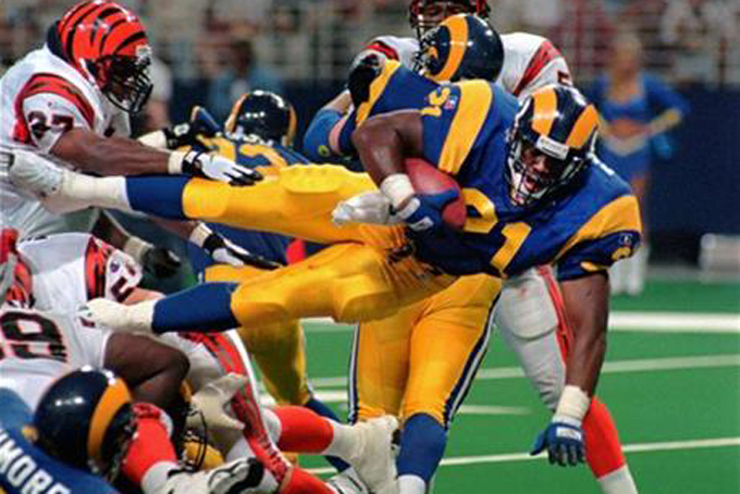 This Sunday, Sept. 1, 1996, file photo shows St. Louis Rams running back Lawrence Phillips (21) leaping over a mound of players as he scores against the Cincinnati Bengals in St. Louis, Mo. Former NFL running back, Phillips was found dead in his California prison cell early Wednesday, Jan. 13, 2016, and officials said they suspect suicide. (AP Photo/L.G. Patterson, File)