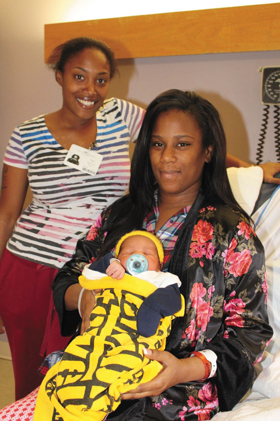 TWO DAYS OLD—Glennice Thomas, pictured here two days after having her son, Djibril Diallo, said its really nice that the hospital does this with the babies since they all were born in Pittsburgh. She also said it doesn’t matter to her what baby Djibril does when he grows up as long as he is happy and he is good at whatever he does. Mattie Thomas, Diallo’s aunt, is a diehard devoted Steelers fan, said, Djibril made her believe even more that the Steelers were going to win. Above, new mother Glennice Thomas holds her 2-day-old Steelers supporter Djibril Diallo wrapped up in the terrible towel, rooting on the Steelers in their playoff bid for the Super Bowl, along with her sister, Mattie Thomas. 