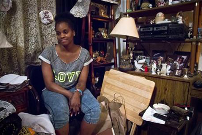 In this Friday, May 22, 2015 photo, Candie Hailey, 32, sits in the small living room of her father's Bronx apartment as she talks about her incarceration at Riker's Island where most of her time was spent in solitary confinement, in New York. (AP Photo/Bebeto Matthews)