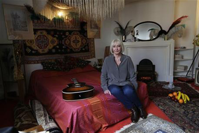 Kathy Etchingham, the former girlfriend of Jimi Hendrix, poses for photographers during a media preview in the bedroom of his former central London flat, at 23 Brook Street, London, Monday, Feb. 8, 2016. (AP Photo/Matt Dunham)