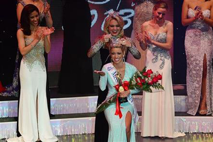 In this June 15, 2013 file photo, Cara McCollum is crowned new Miss New Jersey by Lindsey Petrosh, Miss New Jersey 2012, at the Music Pier in Ocean City, N.J.(Ben Fogletto/The Press of Atlantic City via AP)