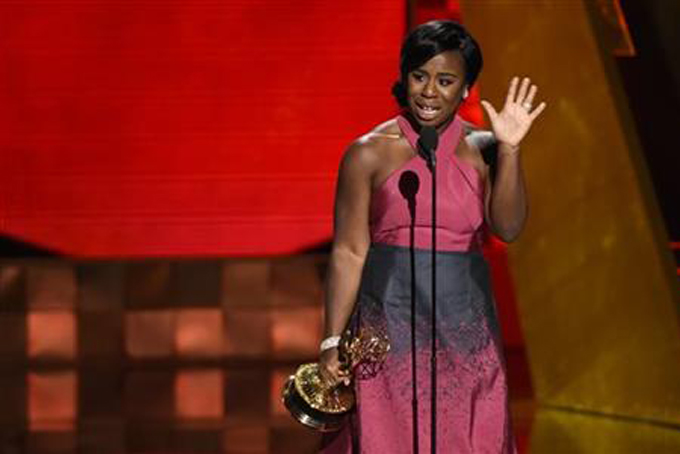 FILE - In this Sunday, Sept. 20, 2015 file photo, Uzo Aduba accepts the award for outstanding supporting actress in a drama series for "Orange Is The New Black" at the 67th Primetime Emmy Awards at the Microsoft Theater in Los Angeles. In one of the exhaustive and damning reports on diversity in Hollywood, a new study finds that the films and television produced by major media companies are “whitewashed,” and that an “epidemic of invisibility” runs top to bottom through the industry for women, minorities and LGBT people. A study to be released Monday, Feb. 22, 2016, by the Media, Diversity and Social Change Initiative at the University of Southern California’s Annenberg School for Communication and Journalism offers one of the most wide-ranging examinations of the film and television industries, including a pointed “inclusivity index” of 10 major media companies - from Disney to Netflix - that gives a failing grade to every movie studio and most TV makers. (Photo by Chris Pizzello/Invision/AP, File)