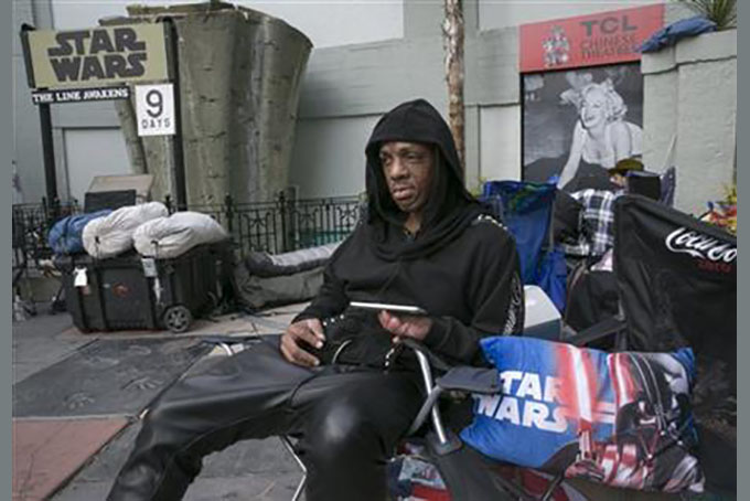 In this Wednesday, Dec. 9, 2015, file photo, Star Wars' fan, Deuce Wayne, from Virginia waits in line outside the TCL Chinese Theatre Imax for the "Star Wars: The Force Awakens" premiere in the Hollywood section of Los Angeles. (AP Photo/Damian Dovarganes, File)