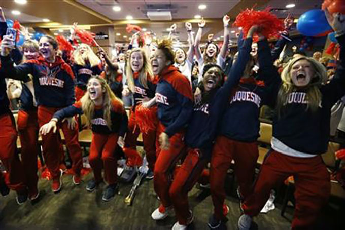 Members of the Duquesne basketball team celebrate as they hear their first-ever berth in the NCAA women's college basketball tournament on Monday, March 14, 2016, in Pittsburgh. Duquesne will play Seton Hall in their first-ever NCAA tournament invitation. (AP Photo/Keith Srakocic)