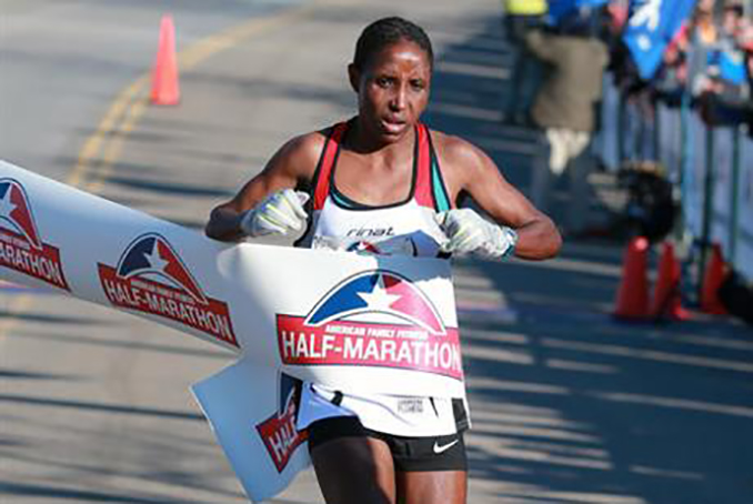 In this Nov. 15, 2014, file photo, Lilian Mariita, of Kenya, wins the women's division of a half-marathon in Richmond, Va. The 27-year-old's racing career is over, and now she is back at square one: in Nyaramba, the muddy tea-plantation village in western Kenya she thought she'd escaped in 2011, when she left for the promise of a new life pounding American roads. (Daniel Sangjib Min/Richmond Times-Dispatch via AP) MANDATORY CREDIT