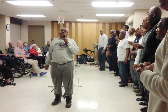 REV. ANTHONY “POPS” MITCHELL leading the choir in song. (Photos by Jackie McDonald)
