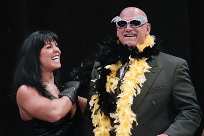 In this July 14, 1999, file photo, Minnesota Gov. Jesse Ventura is adorned with his signature feather boa and glitter sunglasses by professional wrestler Chyna, during a World Wrestling Federation press conference at the Target Center in Minneapolis. (AP Photo/Dawn Villella, File)