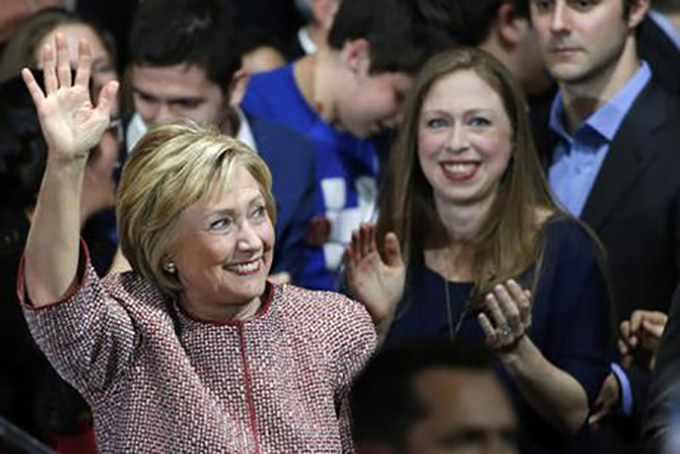 Democratic presidential candidate Hillary Clinton waves to supporters as she enters the room with daughter Chelsea Clinton and son-in-law Mark Mezvinsky after winning the New York state primary election Tuesday, April 19, 2016, in New York. (AP Photo/Kathy Willens)