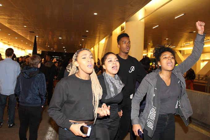 Pitt students protest chanting “No Trump No KKK No Racist USA No Trump.” From left are Jordan Carter, Ami Fall, Staniey Uneweni, and Jamie Christmas. (Photo by J.L. Martello