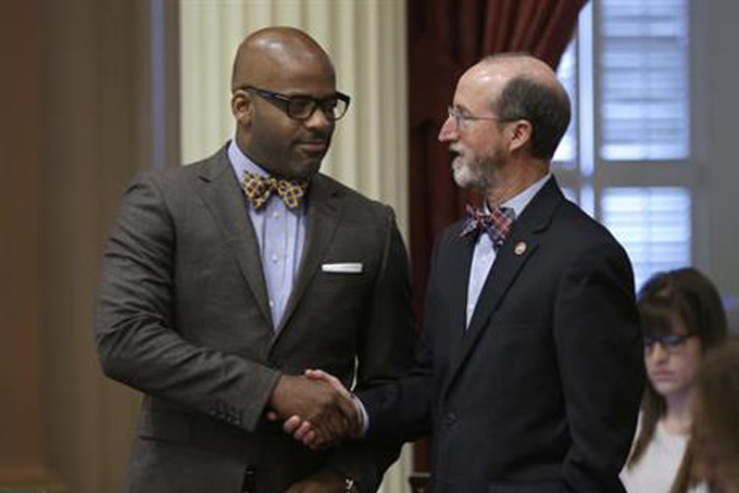 State Senators Isadore Hall III, D-Compton, left, and Steven Glazer, D-Orinda, shake hands after their "bullet button" bill was approved by the Senate, Thursday, May 19, 2016, in Sacramento, Calif. The bill SB880, one of several of a package of gun control measures, was approved the Senate and sent to the Assembly. (AP Photo/Rich Pedroncelli)