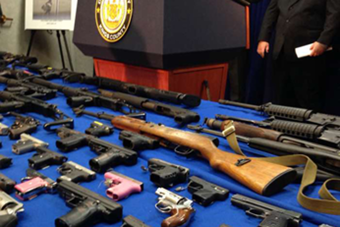 In this Oct. 14, 2015, file photo, weapons are displayed on a table as prosecutors announce arrests in a gun-running scheme that used cheap bus services to smuggle weapons across state lines into New York City, during a news conference at the Brooklyn District Attorney's office in New York.  (AP Photo/Tom Hays, File)