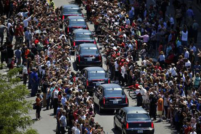 Muhammad Ali's funeral procession passes as onlookers line the street Friday, June 10, 2016, in Louisville, Ky. (AP Photo/Jeff Roberson)
