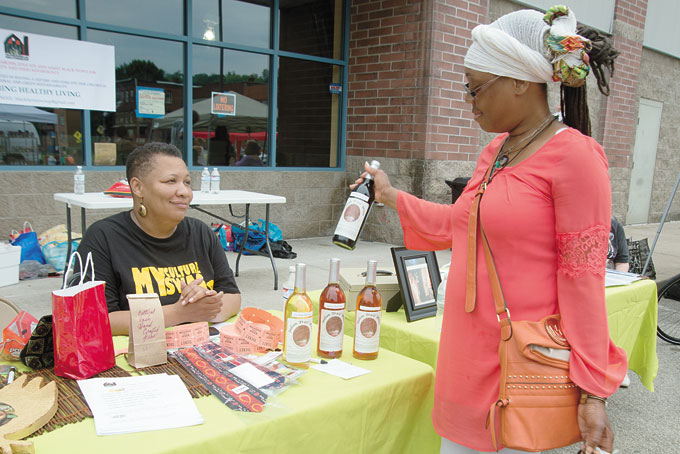 FINE WINE—Dana Harris Yetes talks wine from a local winery with Raqueeb Bey. (Photos by Gail Manker) 