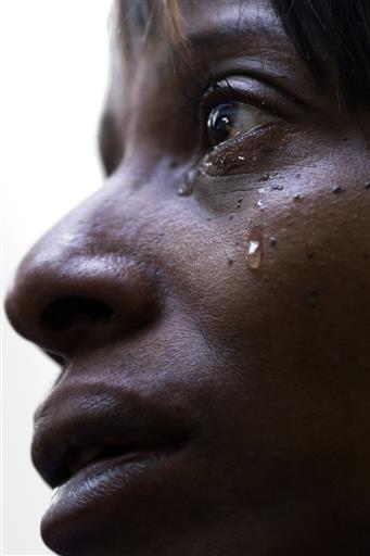 FILE - In this Wednesday, Jan. 23, 2013 file photo, a tear runs down the cheek of Katie Bottoms of Pittsburgh who lost two sons to gun violence, during a CeaseFirePa rally in the Pennsylvania Capital building in Harrisburg, Pa. As a boycott continued to grow over a ban on assault weapons at next month's Eastern Sports and Outdoor Show in Harrisburg, gun rights supporters and gun control supporters held rallies at the state Capitol. (AP Photo/Matt Rourke)