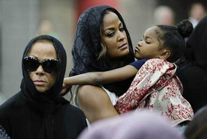 Muhammad Ali's wife Lonnie and her daughter Laila attend Muhammad Ali's Jenazah, a traditional Islamic Muslim service, in Freedom Hall, Thursday, June 9, 2016, in Louisville, Ky. Laila is holding her daughter Sydney Jurldine Conway. (AP Photo/David Goldman)