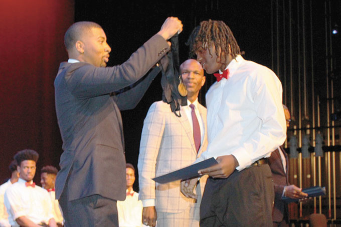 SPECIAL HONOR—Ryan Scott puts the BMLDI metal on Louis Calhoun. 