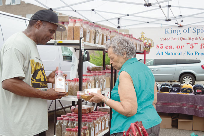 SPICE KING—Mable Bey of Homewood talks to the Spice King Lewis Smith at the Grand Opening of the Homewood Community Farmers Market held at House of Manna Worship Center in Homewood.