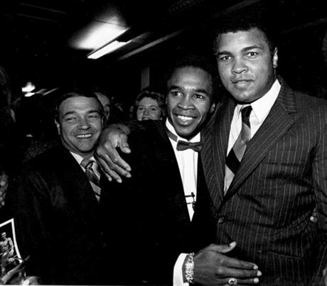 FILE - In this Nov. 9, 1982, file photo Sugar Ray Leonard gets a hug from former world heavyweight champion Muhammad Ali, right, following Leonard's announcement that he is retiring from boxing, in Baltimore, Md. Person at left is unidentified. As Muhammad Ali is laid to rest with a public funeral and private burial, some of the world's most famous faces reflect on a man known simply as "The Greatest." "He was my idol, my friend, my mentor. He was someone that I looked up to and someone who I tried to emulate during my boxing career." — boxer Sugar Ray Leonard. (AP Photo/Bill Smith, File)