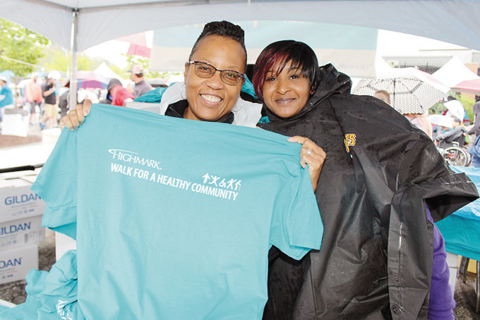 VOLUNTEERS—Cheryl Williams from Garfield and Tonya Cunningham from Downtown help pass out shirts to the walkers.