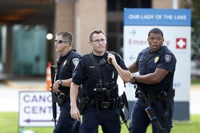 Police guard the emergency room entrance of Our Lady Of The Lake Medical Center, where wounded officers were brought, in Baton Rouge, La., Sunday, July 17, 2016. Multiple law enforcement officers were killed and wounded Sunday morning in a shooting near a gas station in Baton Rouge, less than two weeks after a black man was shot and killed by police here, sparking nightly protests across the city. (AP Photo/Gerald Herbert)