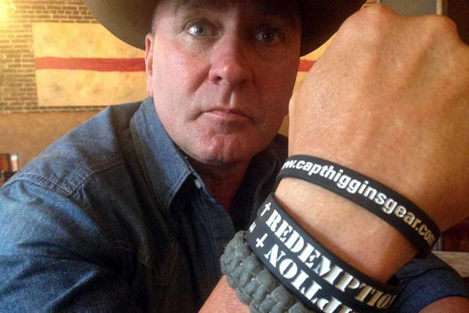 In this June 2, 2016, photo, Clay Higgins, a former Captain for the St. Landry Parish Sheriff's office, and candidate for Congress, poses for a photograph in Lafayette, La. His wristband is printed with the word "redemption." (AP Photo/Kevin McGill)