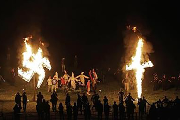 In this Saturday, April 23, 2016 photo, members of the Ku Klux Klan participate in cross and swastika burnings after a 'white pride' rally in rural Paulding County near Cedar Town, Georgia. (AP Photo/Mike Stewart)