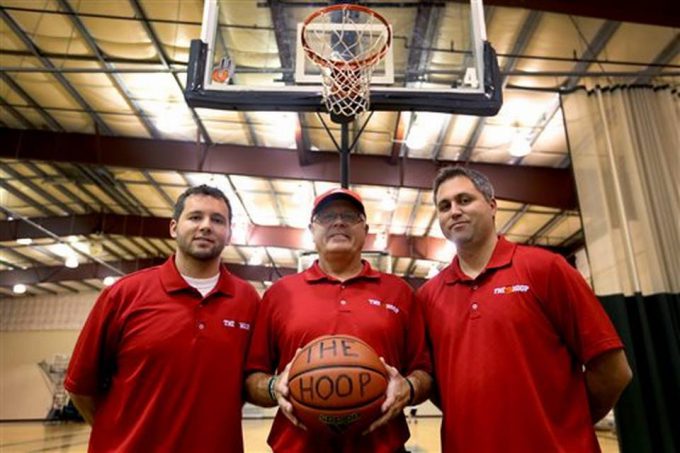 In this Wednesday, Sept. 7, 2016 photo, Price Johnson, center, and his sons Dane Johnson, left, and James Johnson, right, own and operate The Hoop, a competitive basketball training facility in Salem, Ore. The Hoop in Salem is a full fitness center. It is rented for various activities including volleyball, roller skating and wedding receptions. Statesman-Journal via AP Anna Reed 