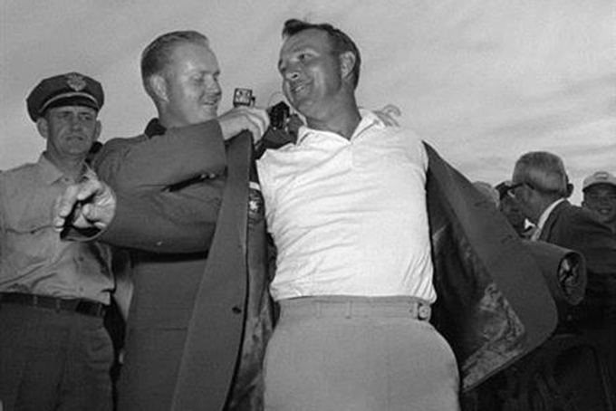 FILE - In this April 12, 1964 file photo, Arnold Palmer, right, slips into his green jacket with help from Jack Nicklaus after winning the Masters golf championship, in Augusta, Ga. Palmer, who made golf popular for the masses with his hard-charging style, incomparable charisma and a personal touch that made him known throughout the golf world as "The King," died Sunday, Sept. 25, 2016, in Pittsburgh. He was 87. (AP Photo/File)