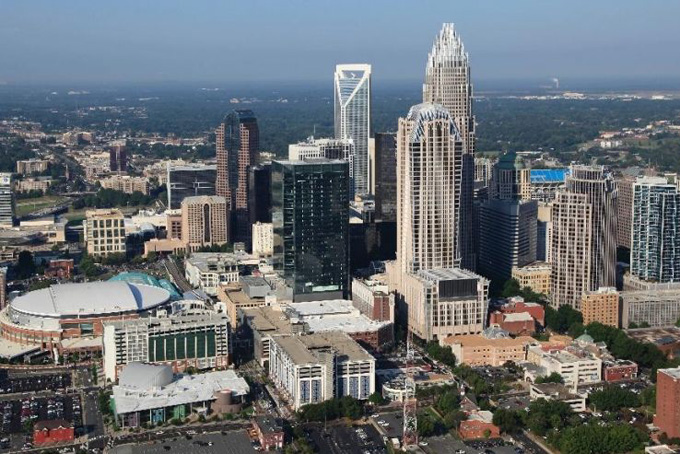 In this Aug. 16, 2012 file photo, the Time Warner Cable Arena is shown on left of downtown Charlotte, N.C. To much of the world, Charlotte is the Queen City, a gleaming downtown, state-of-the-art stadiums, sparkling new mass transit, the nation's banking capital. But a very different Charlotte came into the spotlight in the past few days. Move outside the city's core and there are neighborhoods like the one where a police officer shot and killed a black man, Keith Scott, Sept. 20, 2016, setting off violent protests.(AP Photo/Chuck Burton) (The Associated Press) 