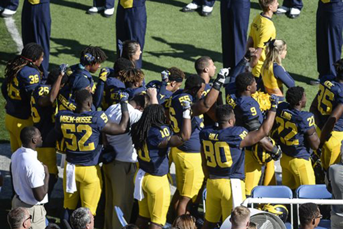Michigan football players raise their fists up in protest during the National Anthem, before an NCAA college football game against Penn State, Saturday, Sept. 24, 2016, in Ann Arbor, Mich. (Junfu Han/The Ann Arbor News via AP)