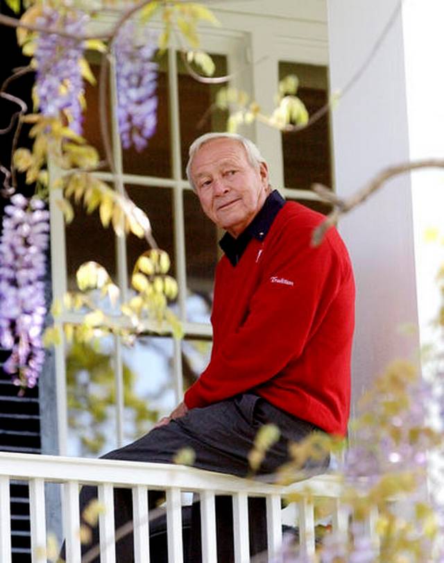  FILE--This 2004 file photo shows former Masters champion Arnold Palmer as he sits on clubhouse railing at the Augusta National Golf Club in Augusta, Ga. Palmer, who made golf popular for the masses with his hard-charging style, incomparable charisma and a personal touch that made him known throughout the golf world as "The King," died Sunday, Sept. 25, 2016, in Pittsburgh. He was 87. David J. Phillip, File AP Photo 