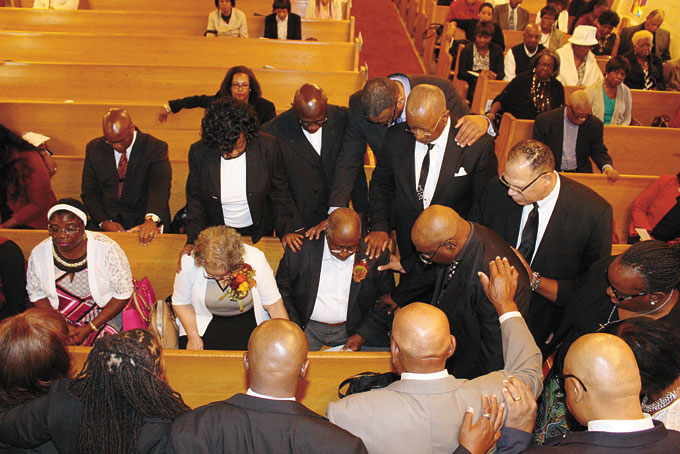 SPECIAL HONOR—A concert celebrating the legacy of Rev. Dr. J.V.A. Winsett, pastor emeritus of Ebenezer Baptist Church, was held at Bethel AME Church on Webster Avenue, both located in the Hill District. The Family and Friends Choir, along with his sons and daughters in the ministry, took part in honoring Rev. Dr. Winsett for his more than 50 years of service. In the photo above, Rev. Dr. Winsett’s sons and daughters in the ministry gathered around the Winsetts to pray over them. (Photos by J.L. Martello) 