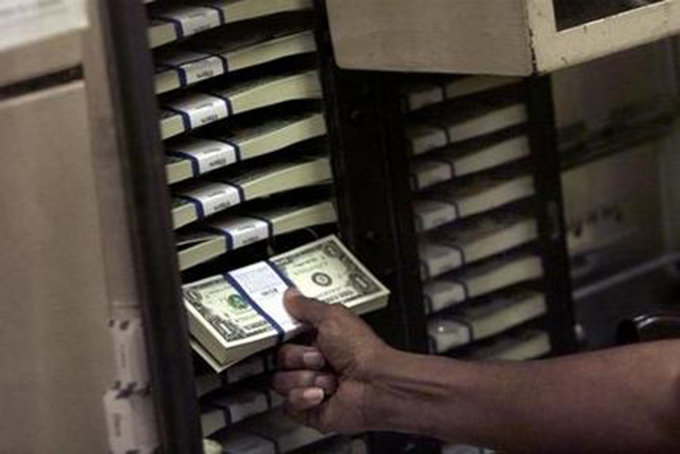 In this April 24, 2001 file photo, a Bureau of Printing and Engraving employee checks one dollar bills at the plant in Washington. When the bills are due, more young blacks and Latinos feel like they can’t turn to Mommy, Daddy or even Grandma to help them out of financial trouble than whites or Asians, according to a new Associated Press poll. (AP Photo/Hillery Smith Garrison, File)