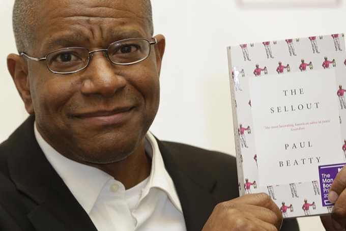 Paul Beatty, from the United States, winner of the 2016 Man Booker Prize for fiction poses for the media with his book "The Sellout" after the award ceremony in London, on Oct. 25, 2016.  (Alastair Grant / AP)