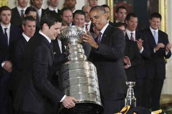 President Barack Obama helps Pittsburgh Penguins team captain Sidney Crosby carry the Stanley Cup during a ceremony honoring the Stanley Cup champion Pittsburgh Penguins, Thursday, Oct. 6, 2016, during a ceremony in the East Room of the White House in Washington. (AP Photo/Manuel Balce Ceneta)