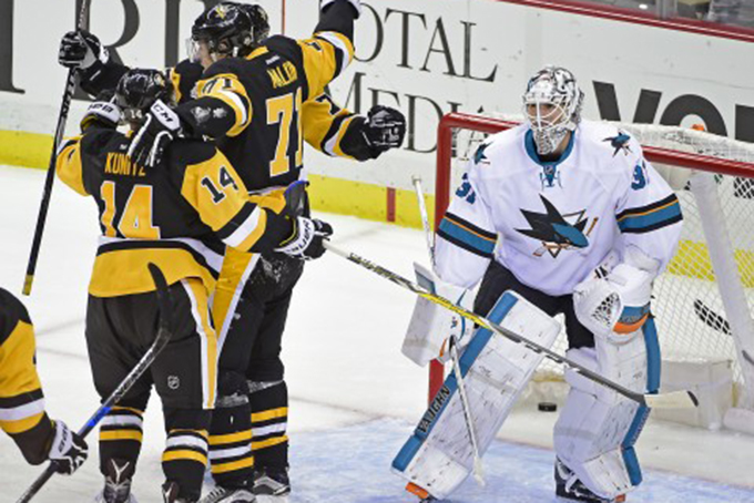 Pittsburgh Penguins left wing Chris Kunitz (14), center Evgeni Malkin (71) and Pittsburgh Penguins right wing Patric Hornqvist (72) celebrate the winning goal in front of San Jose Sharks goalie Martin Jones (31) during the third period of an NHL hockey game on Thursday, Oct. 20, 2016, in Pittsburgh. The Penguins defeated the Sharks 3-2. (Fred Vuich/Associated Press)