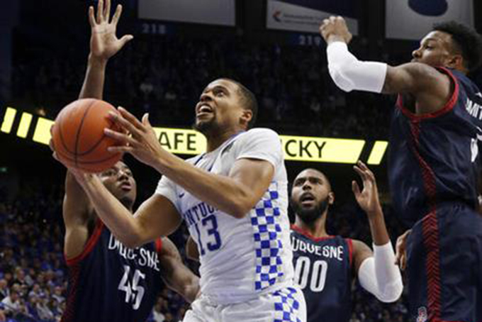 Kentucky's Isaiah Briscoe (13) shoots between Duquesne's Isiaha Mike, left, Darius Lewis (00) and Tarin Smith during the second half of an NCAA college basketball game, Sunday, Nov. 20, 2016, in Lexington, Ky. (AP Photo/James Crisp)