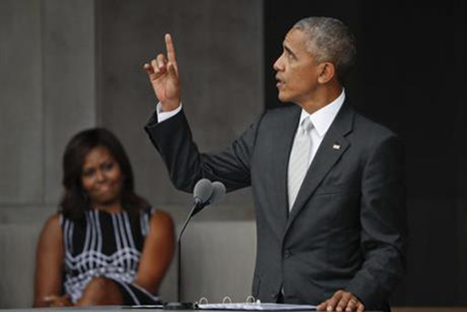 In this Saturday, Sept. 24, 2016 file photo, President Barack Obama points upward during the dedication ceremony for the Smithsonian Museum of African American History and Culture on the National Mall in Washington. “It is a monument, no less than the others on this Mall, to the deep and abiding love for this country, and the ideals upon which it is founded. For we, too, are America," he said. At left is first lady Michelle Obama. (AP Photo/Pablo Martinez Monsivais)
