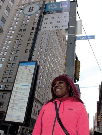 PAYING MORE—Ilea Washington waits at her bus stop Downtown for a ride that costs $2 more per day than it did in December because she pays cash and paper transfers have been eliminated.